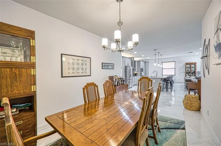 Tiled dining space with sink and an inviting chandelier