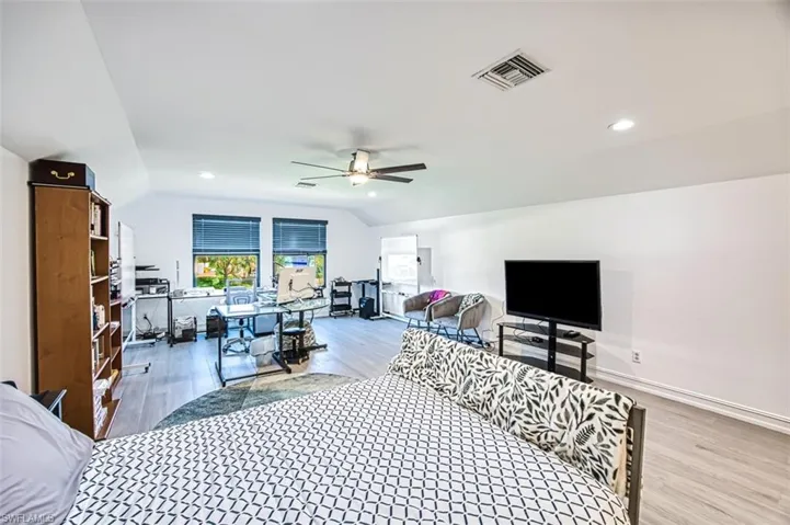 Bedroom featuring lofted ceiling and wood-type flooring