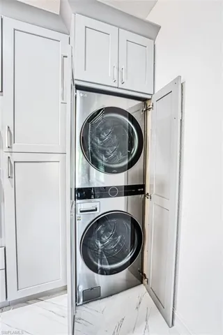 Laundry room with cabinets and stacked washer / drying machine