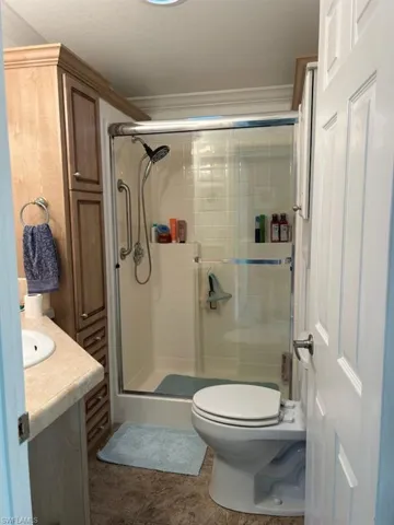 Bathroom with walk in shower, vanity, tile floor
