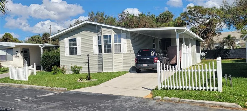 View of front of property featuring a carport and a front yard