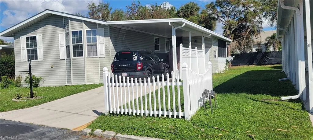 View of home's exterior featuring a carport and a lawn