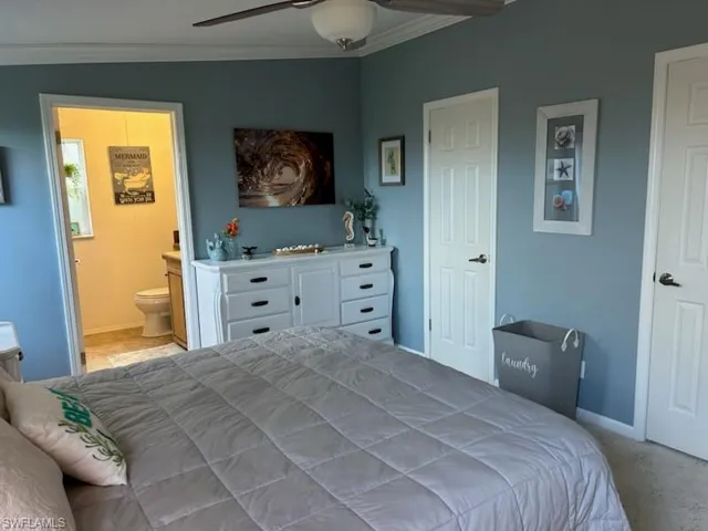 Primary Bedroom with ensuite bath, vaulted ceiling, ceiling fan, and crown molding