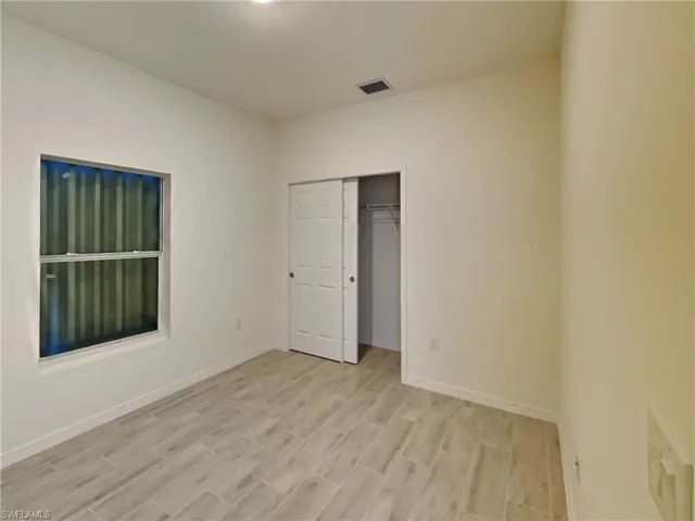 photo is of a previously completed home  Unfurnished bedroom with a closet and light hardwood / wood-style floors