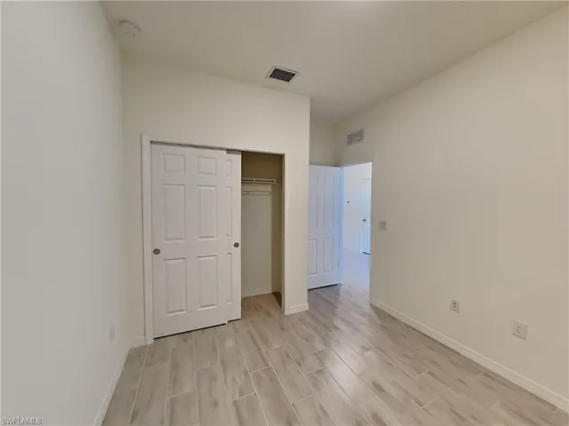 photo is of a previously completed home  Unfurnished bedroom featuring a closet and light hardwood / wood-style flooring