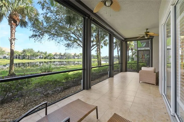Unfurnished sunroom with a ceiling fan and a water view