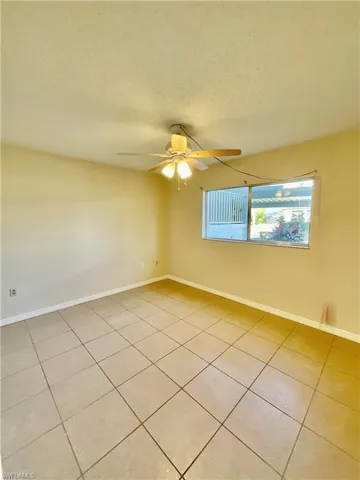 Unfurnished room featuring light tile patterned floors, a textured ceiling, and ceiling fan
