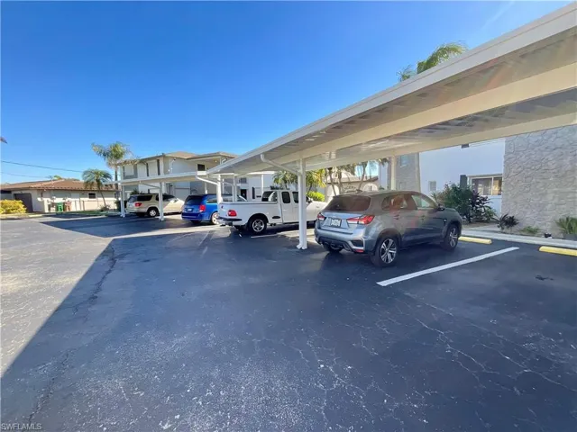 View of parking / parking lot featuring a carport