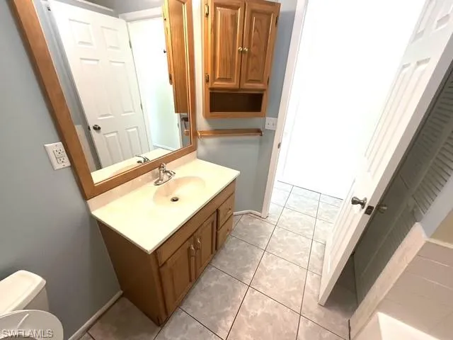 Half bathroom with light tile patterned floors and vanity