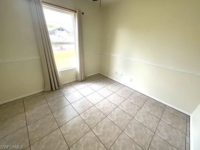 Unfurnished room featuring light tile patterned floors and ceiling fan