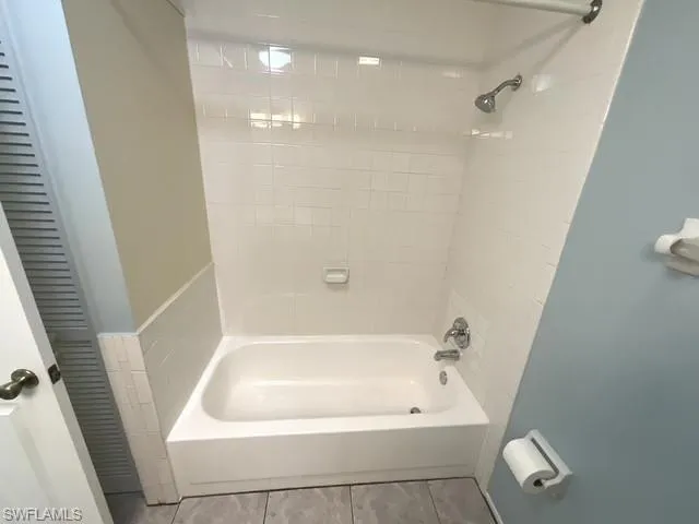 Bathroom featuring bathing tub / shower combination and tile patterned flooring