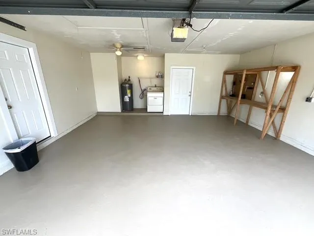 Garage with water heater, washer / dryer, and a garage door opener