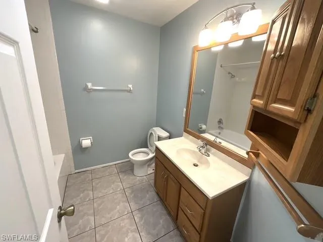 Full bathroom with shower / washtub combination, light tile patterned floors, and vanity