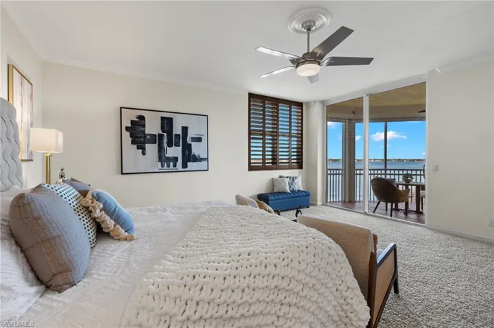 Bedroom with ceiling fan, a water view, ornamental molding, carpet flooring, and access to exterior