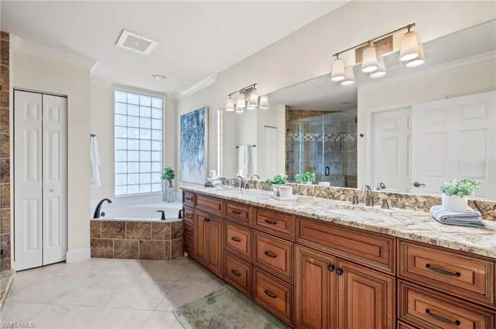 Bathroom with shower with separate bathtub, double vanity, crown molding, and tile patterned flooring