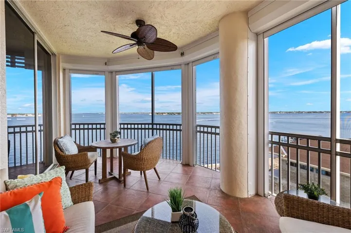 Sunroom with a healthy amount of sunlight, a water view, and ceiling fan
