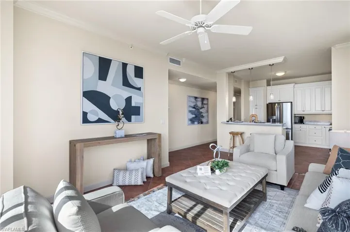 Living room featuring ornamental molding and ceiling fan