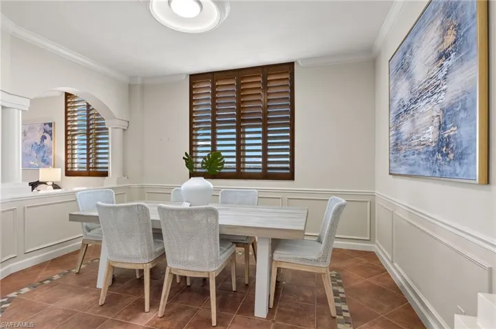 Dining room with a healthy amount of sunlight, tile patterned floors, and ornamental molding