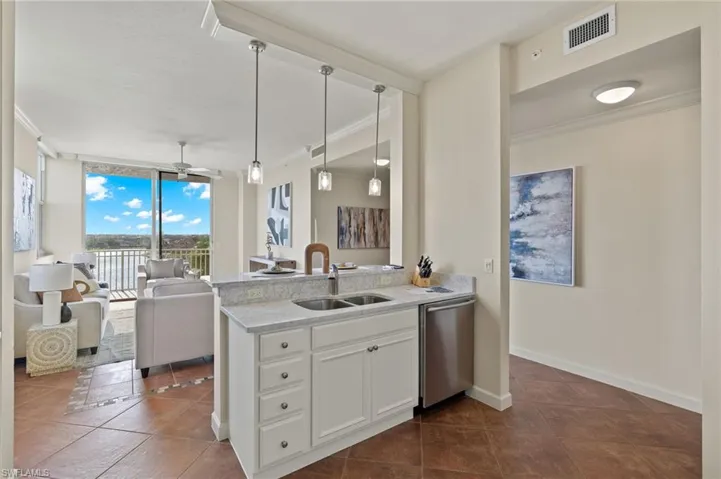 Kitchen featuring stainless steel dishwasher, ceiling fan, white cabinets, sink, and dark tile patterned flooring