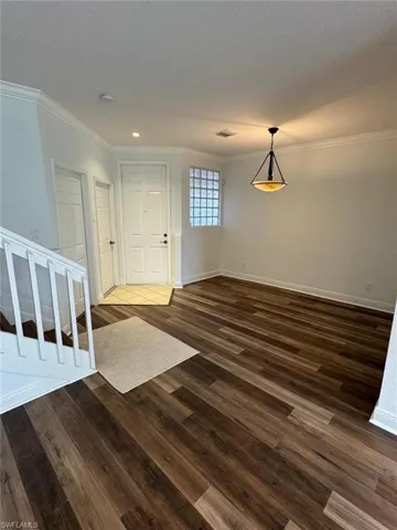 Foyer featuring ornamental molding and dark hardwood / wood-style floors