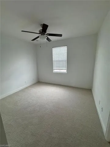 Unfurnished room featuring ceiling fan and light colored carpet