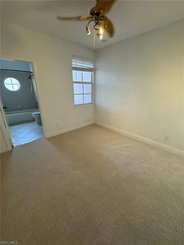 Unfurnished room featuring light carpet and ceiling fan