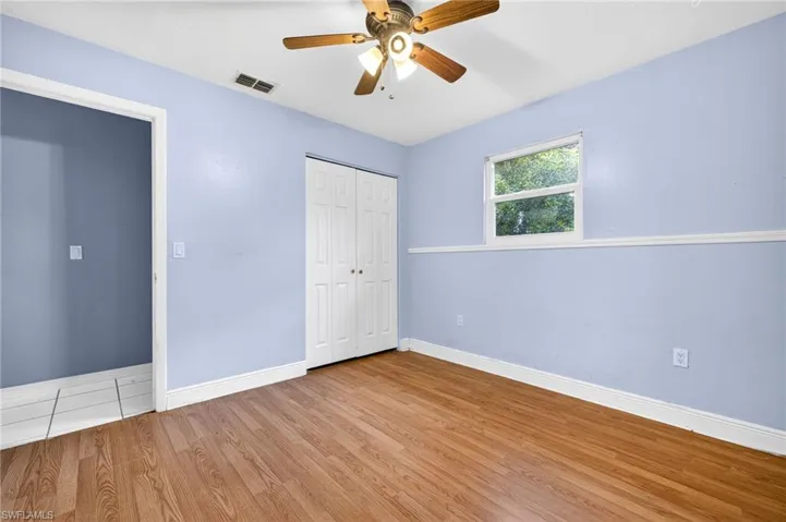 Unfurnished bedroom with wood finished floors, ceiling fan, and a closet