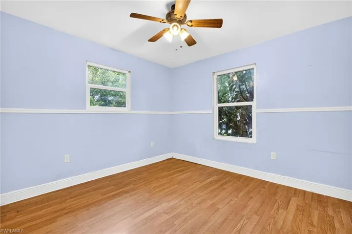 Spare room with wood finished floors and ceiling fan