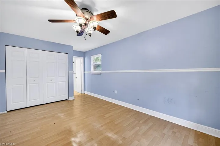 Unfurnished bedroom with wood finished floors, a closet, and ceiling fan