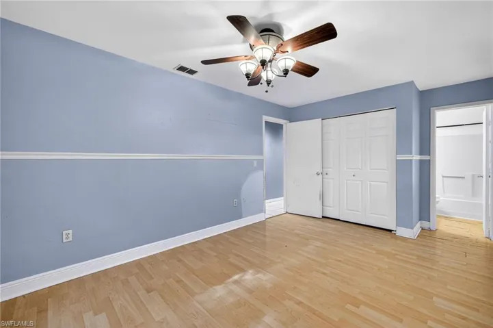 Unfurnished bedroom featuring wood finished floors, ceiling fan, and a closet