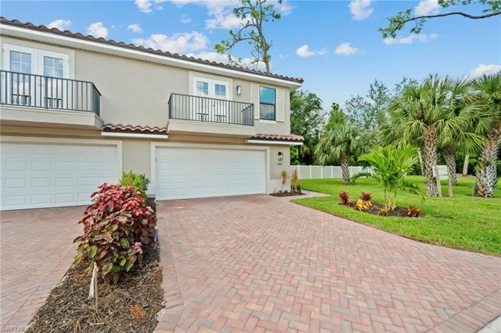 Mediterranean / spanish home featuring a balcony, a garage, and a front yard