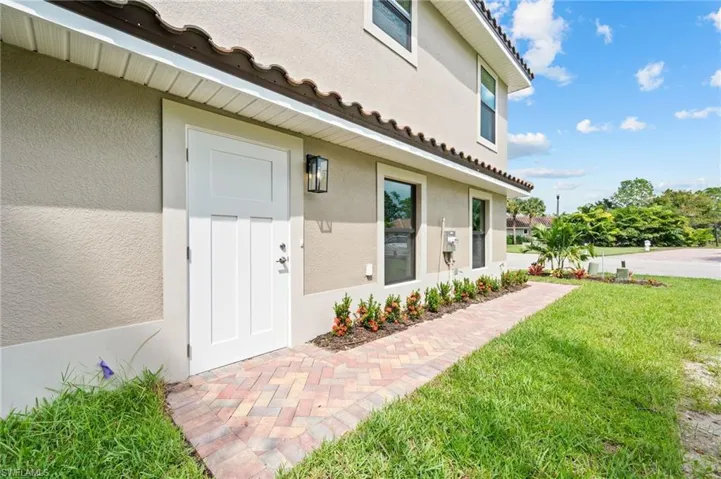 View of exterior entry featuring a yard