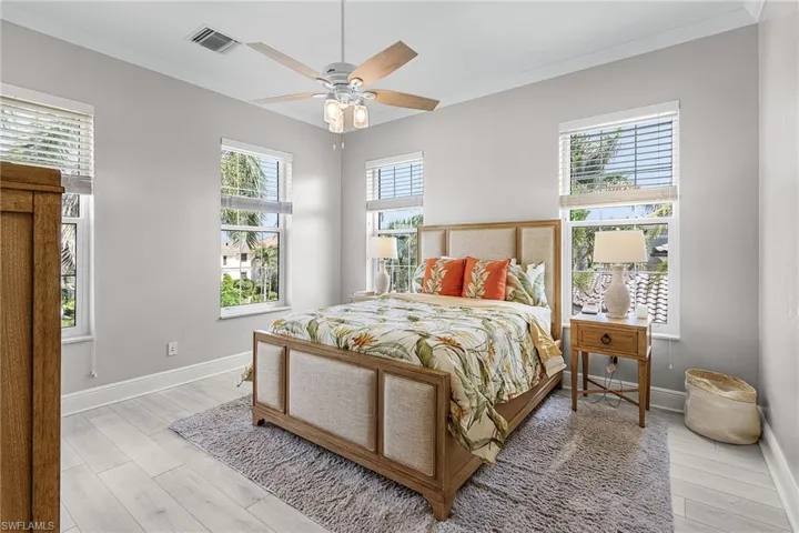 Bedroom featuring crown molding, light wood finished floors, and a ceiling fan