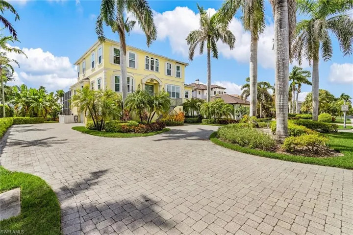 View of front facade featuring curved driveway and stucco siding