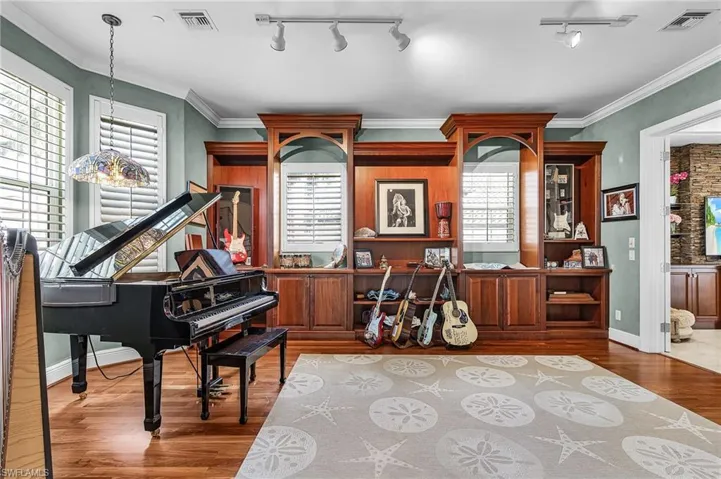 Sitting room with wood finished floors, rail lighting, and crown molding