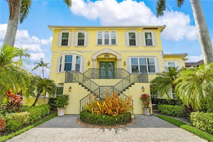 Italianate-style house featuring stucco siding, stairs, and a balcony