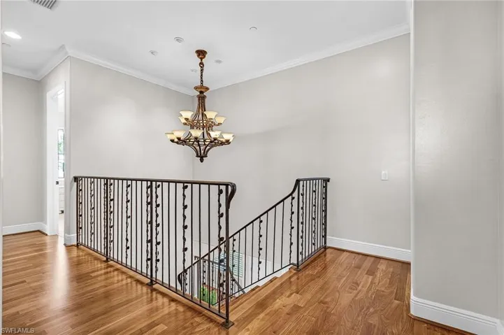 Staircase featuring ornamental molding, a chandelier, wood finished floors, and recessed lighting