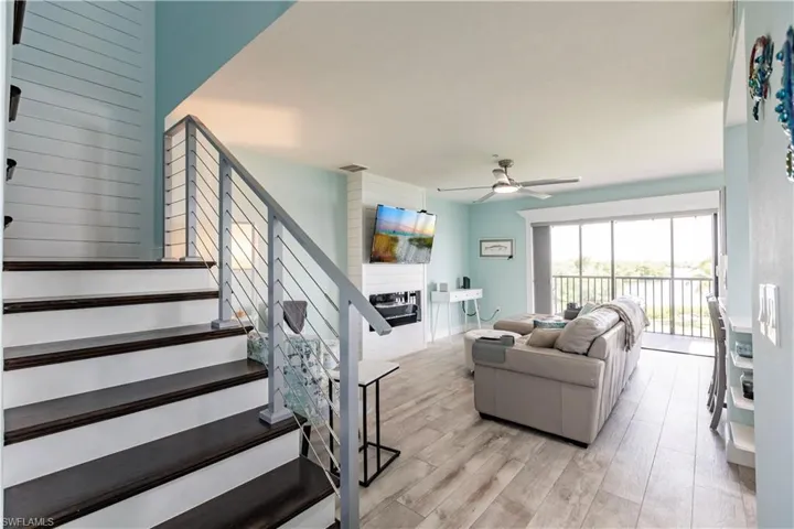Living room with ceiling fan and light hardwood / wood-style floors