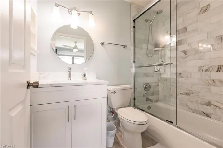 Full bathroom with vanity, toilet, and combined bath / shower with glass door