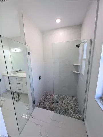 Bathroom featuring vanity and a shower with shower door