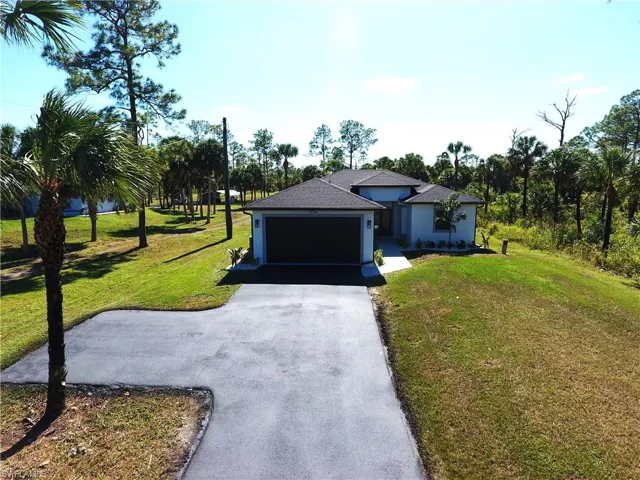 View of front of property featuring a front lawn and a garage