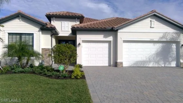 WELOME HOME featuring decorative driveway, a garage, a tiled roof, and stucco siding