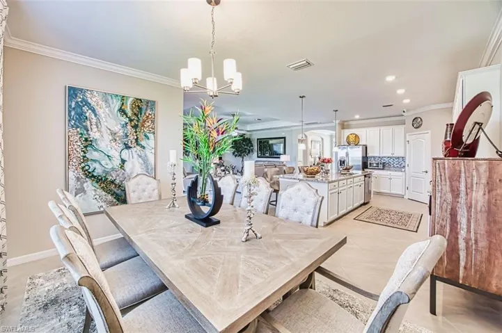 Dining space featuring crown molding, light tile patterned floors