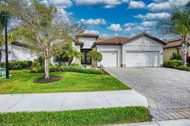 Mediterranean / spanish-style house with stone siding, a tiled roof, decorative driveway, a garage, and stucco siding