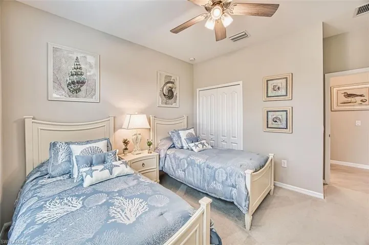 Bedroom featuring a closet, ceiling fan, and light carpet
