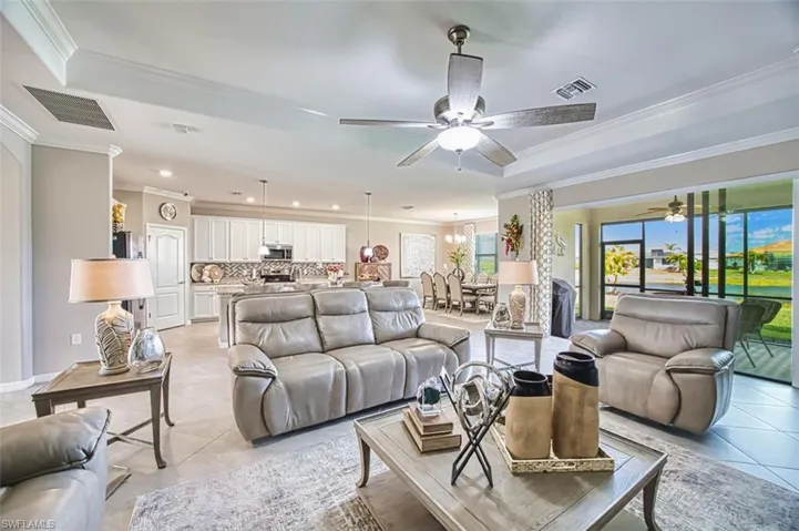 Living area with ceiling fan, crown molding, light tile patterned floors, and hanging lights