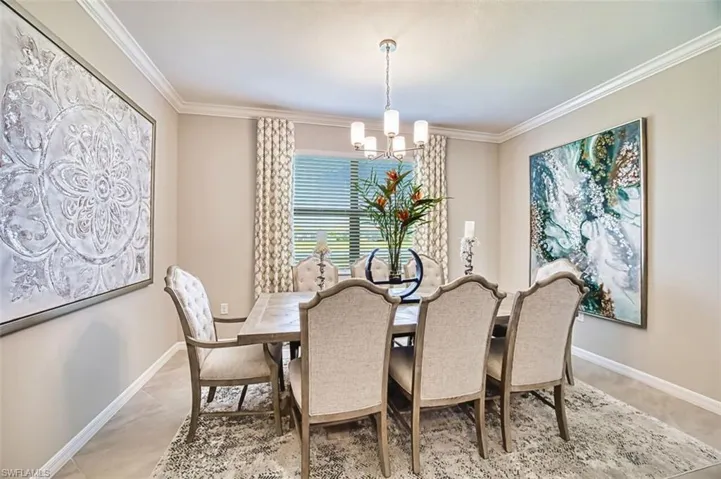 Dining area with hanging lights and crown molding