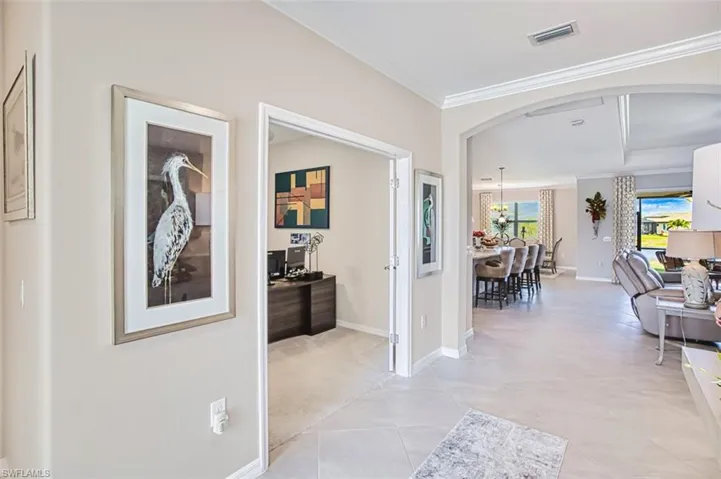 Entry  featuring arched walkways, crown molding, and light tile patterned floors