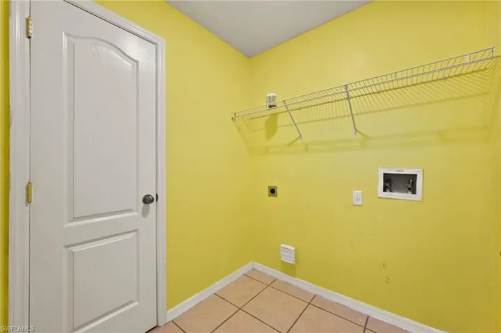 Laundry room featuring washer hookup, electric dryer hookup, and light tile patterned floors