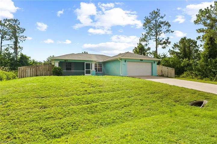 Single story home with concrete driveway, an attached garage, and stucco siding